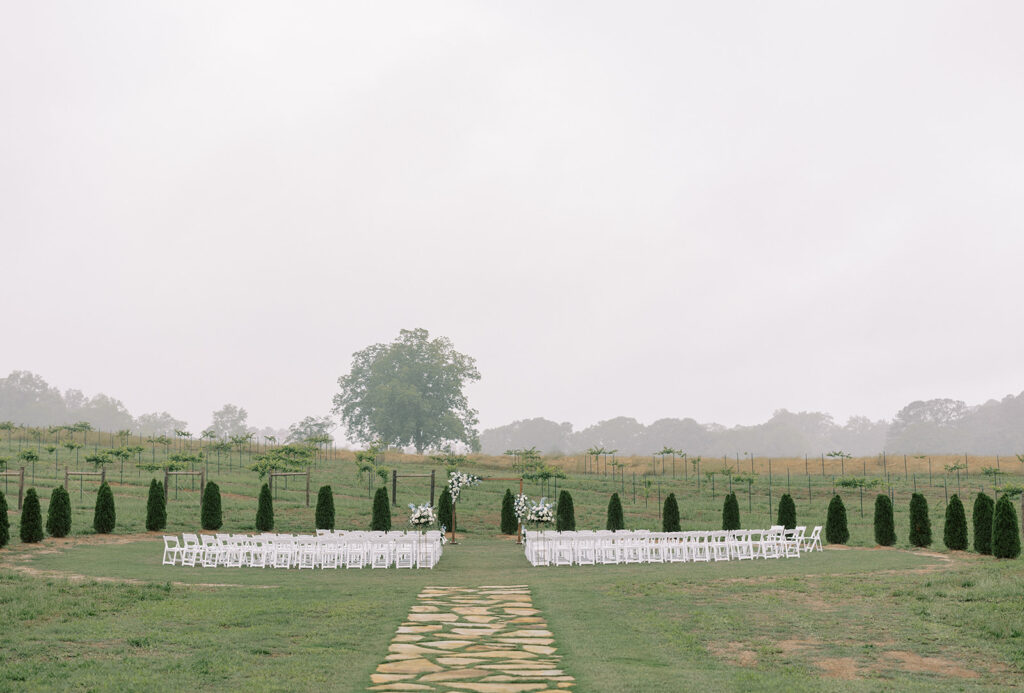 a stone walkway going to a wedding ceremony site in a vineyard