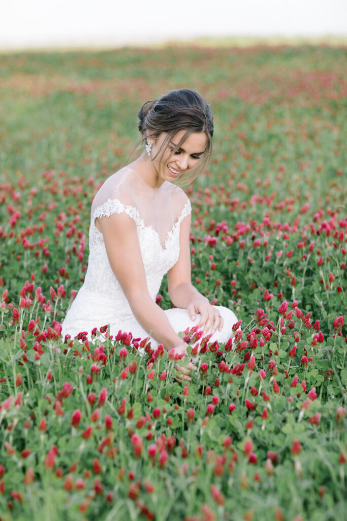 Beautiful bride in her wedding dress in the crimson clover field at a wedding venue located near Atlanta, GA