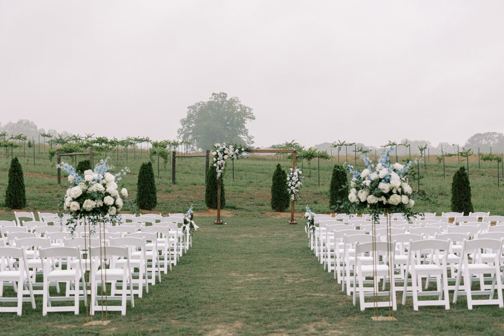 Outdoor wedding ceremony with beautiful florals in the vineyard at a wedding venue located near Atlanta