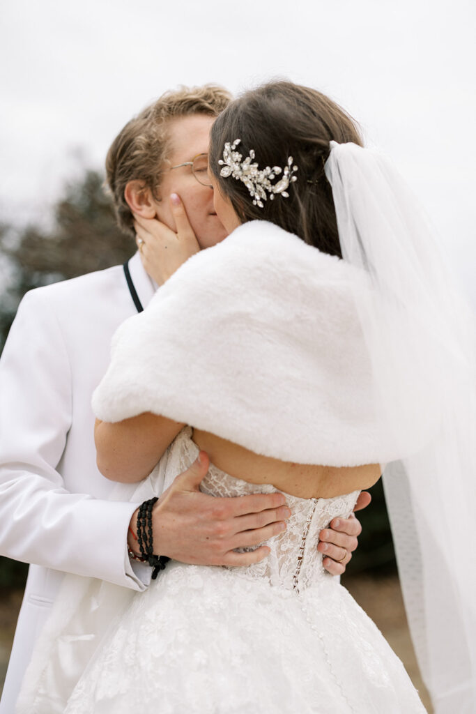 December bride with wedding dress and fur stole and groom in white dinner coat and black pants at a wedding venue in Newnan, GA