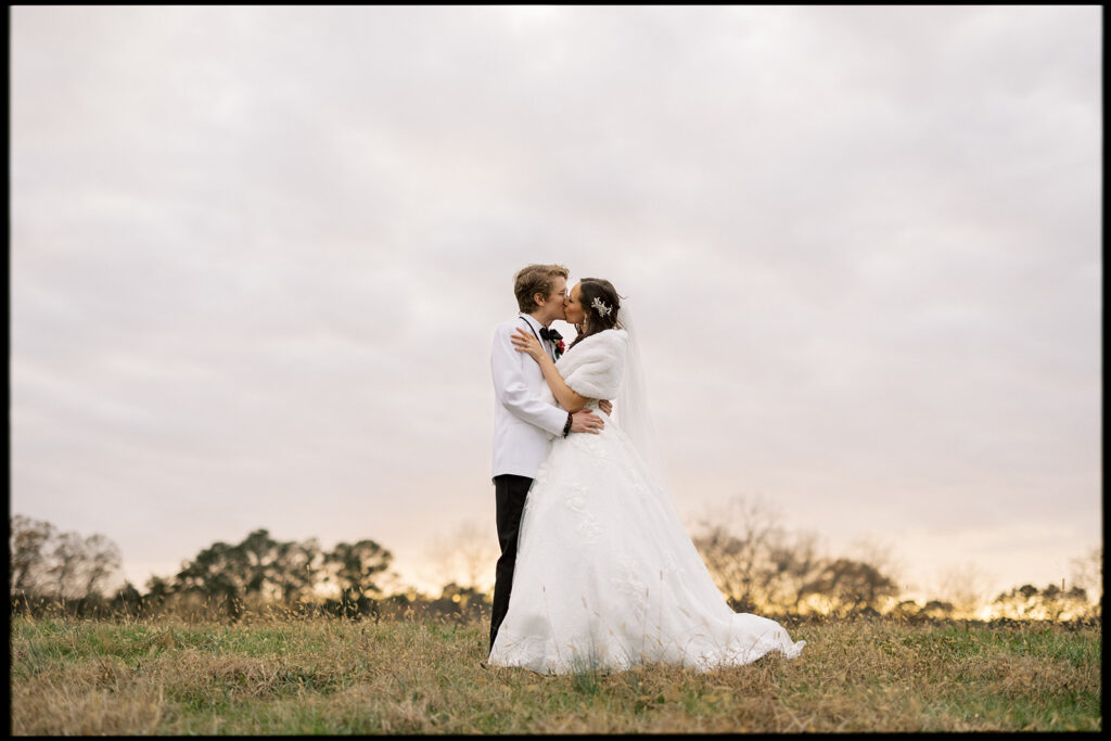 Golden hour bridal portraits with the bride and groom in the wide open fields by local photographer at an outdoor wedding venue located near Atlanta