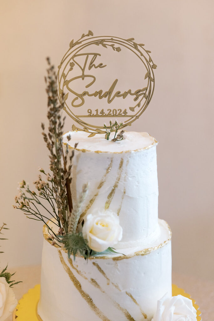 Wedding cake from local baker with fresh florals and cake topper for a wedding reception at a venue located near Atlanta 