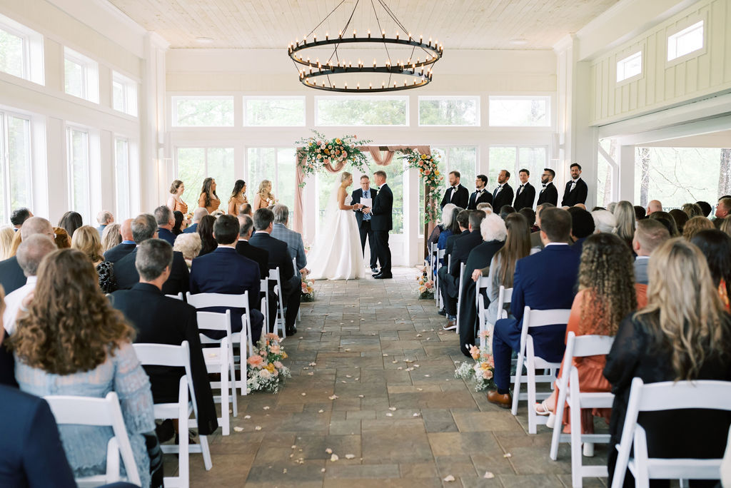 Natural light shines through the glass enclosed windows at an indoor wedding ceremony at The Venue at Murphy Lane located in Newnan, GA