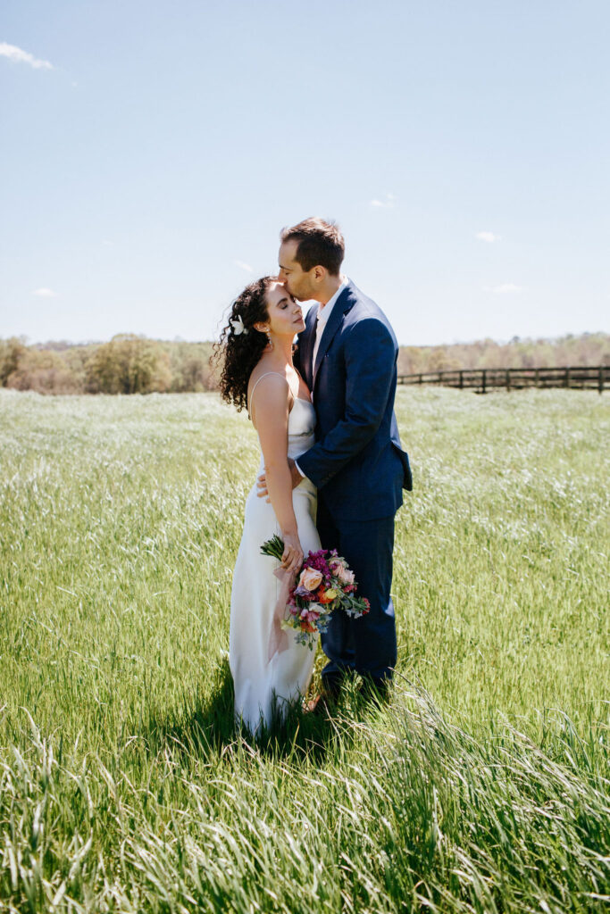 Bride and groom on wedding day with bridal bouquet in wide open fields at a wedding venue located in Newnan, Georgia