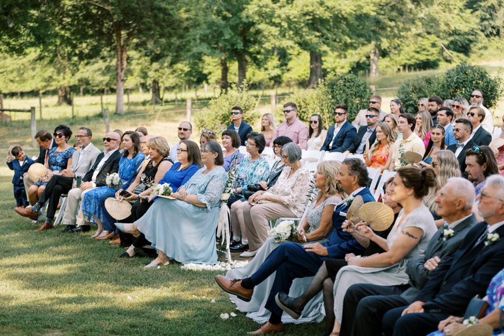 Guests attending the beautiful spring outdoor wedding ceremony in the valley at the The Venue at Murphy Lane located in Newnan, GA about 1 hour away from Atlanta 